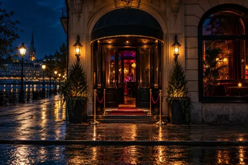 A nightclub entrance on a wet street at night.